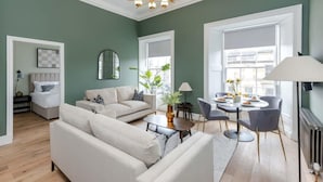 A modern living room with a sofa, coffee table, and dining area. - Jade Suite - City Centre 2 Bed Luxury Apartment (Edinburgh)