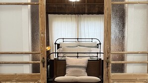 A rustic room with a bunk bed, wooden walls, and a ceiling fan. - Centrally located Turn of the Century Beauty! (Kerrville)