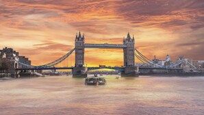 A suspension bridge with towers and cables, spanning a body of water with a cityscape in the background. - Attractive Tower Bridge Apartment! 2 mins from the river side! (LONDON)