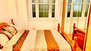 A bedroom with a wooden bed, a window with blinds, and a view of the outside. - Attractive Tower Bridge Apartment! 2 mins from the river side! (LONDON)