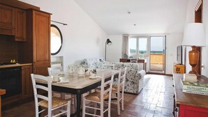 Une cuisine chaleureuse avec des meubles en bois, un miroir rond et un coin repas avec une table dressée pour quatre personnes.