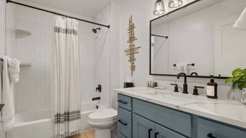 A modern bathroom with a shower, toilet, and vanity.