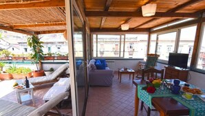 A covered outdoor seating area with a sofa, chairs, and a dining table. - Case Cosi Napoli - APP 17 (Naples)