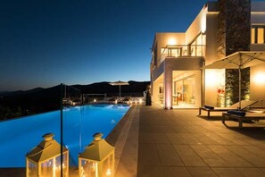 Un hôtel moderne doté d’une piscine, d’un espace extérieur aménagé et offrant une vue sur les montagnes.