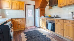 A kitchen with wooden cabinets, a refrigerator, a stove, and a microwave. - Melrose 2 (Lancaster)