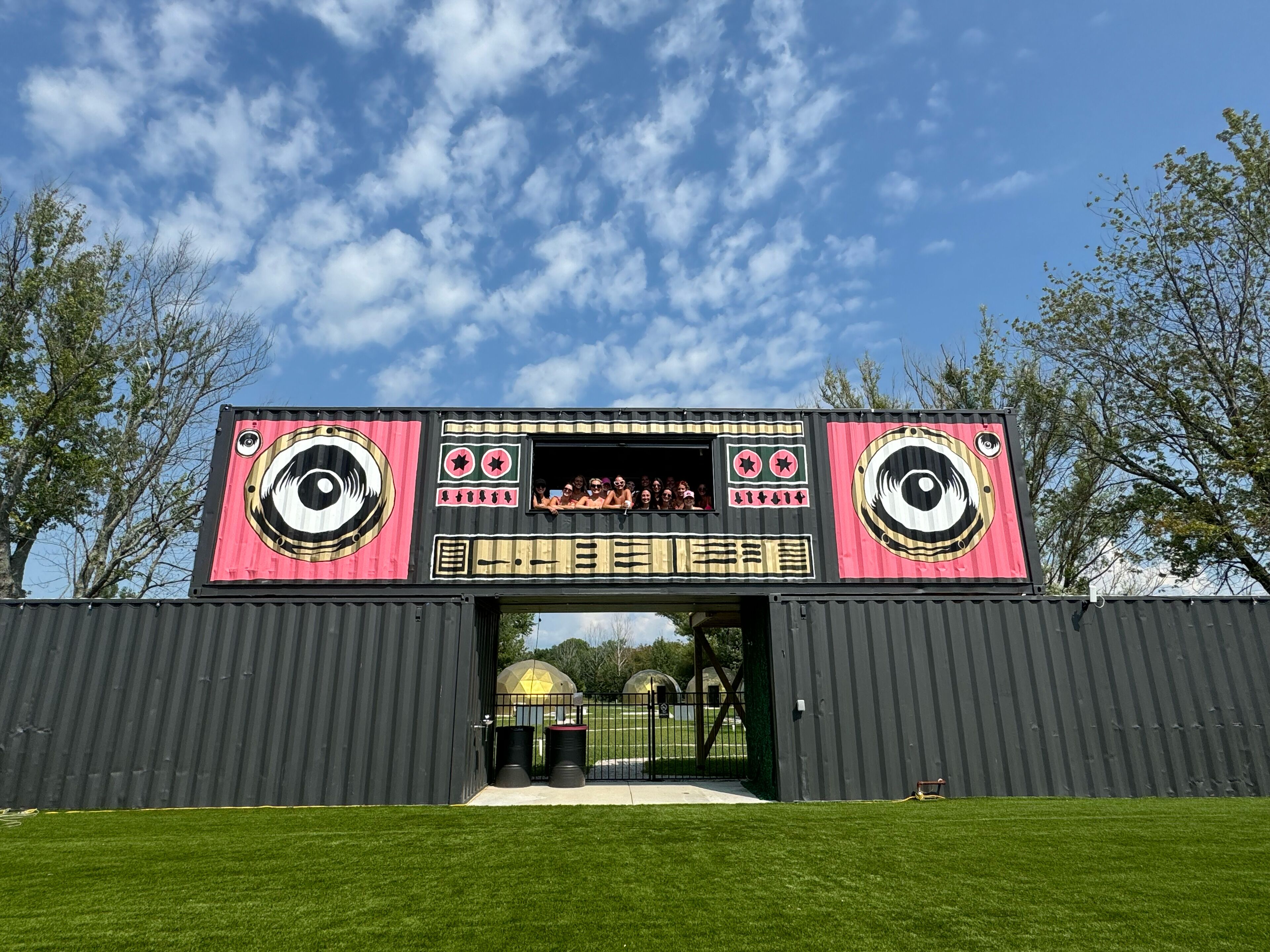 A large, colorful structure with eye motifs and text, likely a themed attraction or event space.