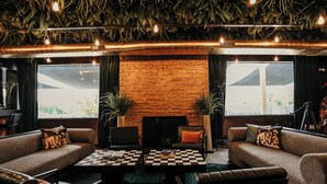 A cozy lounge area with a checkered coffee table, sofas, and a fireplace. - DayDreamer Domes (South Haven)