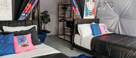 A bedroom with two beds, a ceiling fan, and a large window with curtains.