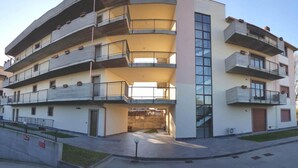 A multi-story residential building with balconies, a central entrance, and a parking area. - Case Cosi Verona - Appartamento 1-4 (Verona)