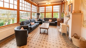 A spacious living room with large windows, a fireplace, and a cozy seating area. - Holiday Home With Character in Stavelot (Stavelot)