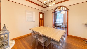 A dining area with a wooden table and clear chairs, a chandelier, and a wooden floor. - Holiday Home With Character in Stavelot (Stavelot)