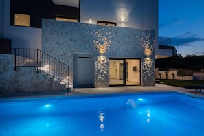 A modern building with a stone facade, a swimming pool, and a well-lit entrance. - Villa Salt - 8 2 Heated Pool Trogir Near Beach (Trogir)
