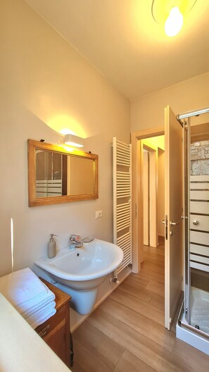 Ein Badezimmer mit Waschbecken, Spiegel und Handtuchhalter.