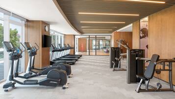 A gym with treadmills, elliptical machines, and weight equipment.