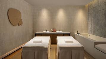 Experience a spa-like atmosphere in this serene bathroom, featuring two massage tables and a large bathtub.