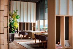 A modern interior with a dining area, a large window, and a view of the city.