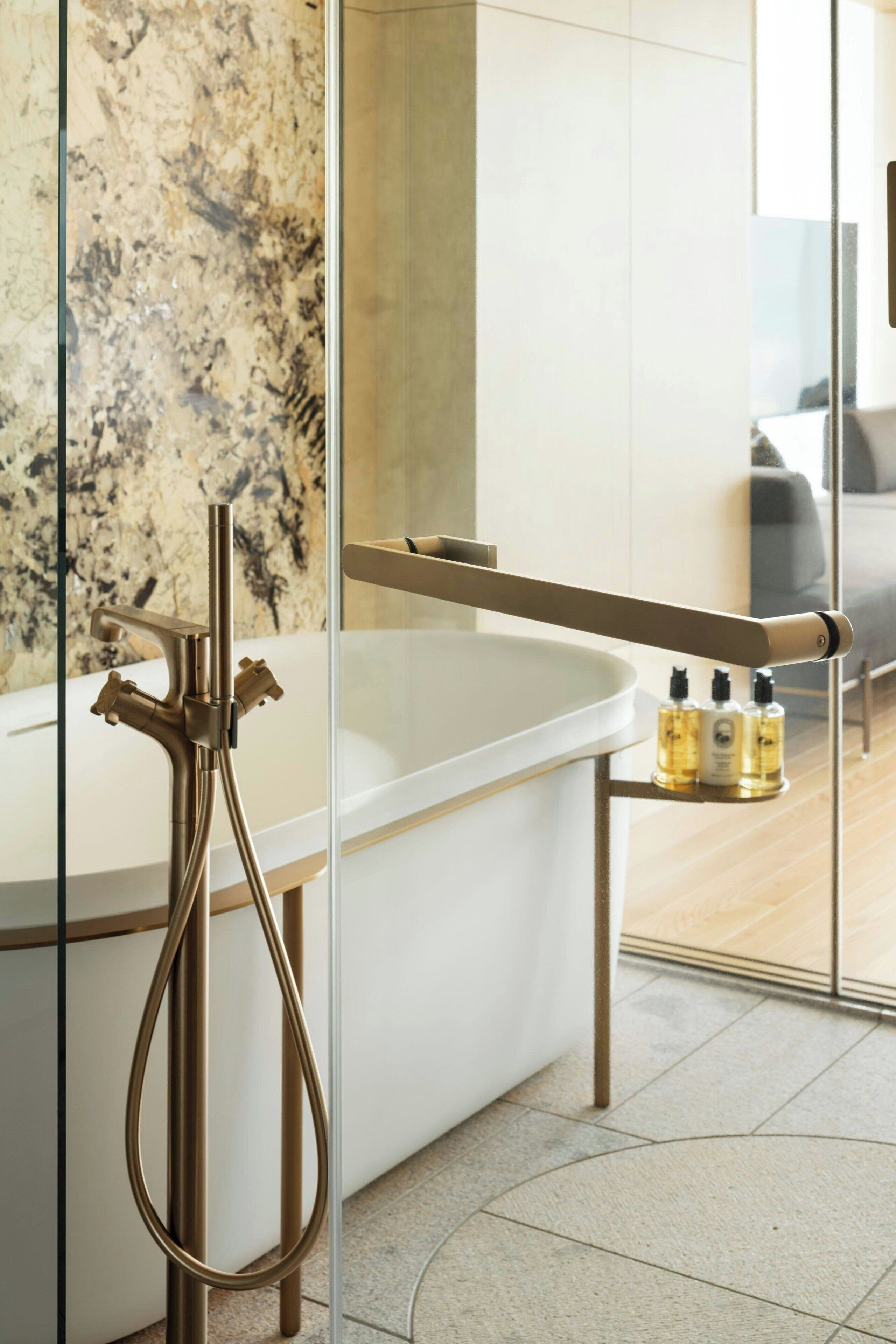 Un baño moderno con una bañera independiente, cabina de ducha de vidrio y un estante pequeño con artículos de aseo.