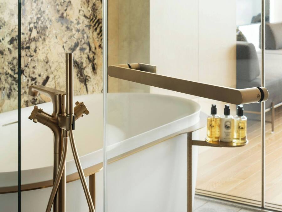 Un baño moderno con una bañera independiente, cabina de ducha de vidrio y un estante pequeño con artículos de aseo.