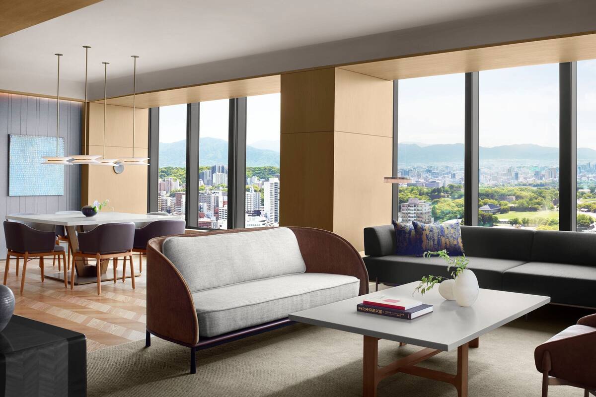 A modern living room with a sofa, coffee table, and dining area.