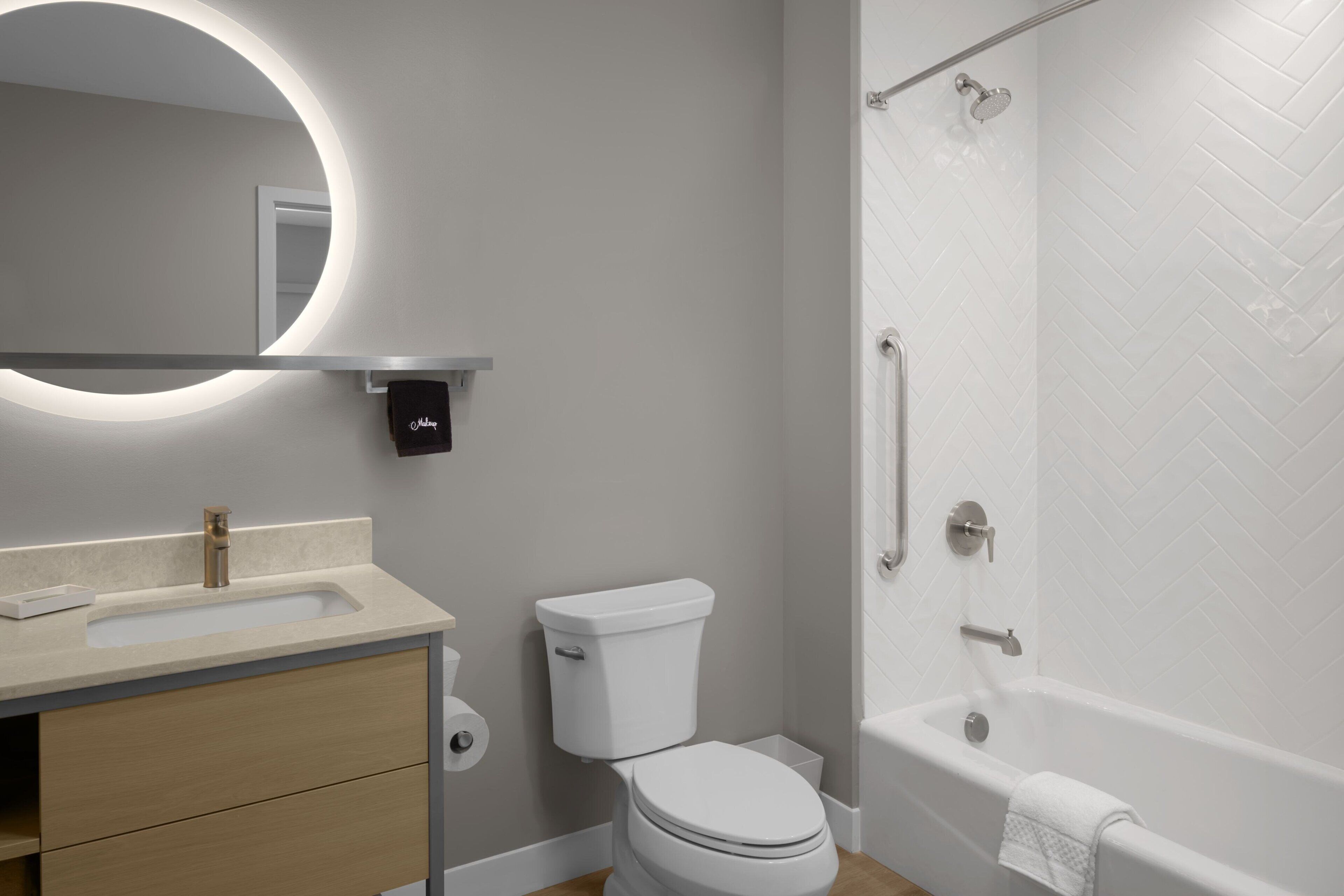 A modern bathroom with a toilet, sink, and shower.
