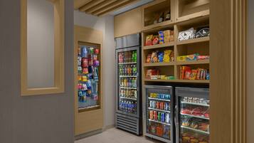 A self-service beverage station with refrigerated drink dispensers and snack shelves.