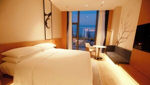 A hotel room with a large bed, a small table, a sofa, and a TV. - Fairfield By Marriott Zibo (Zibo)