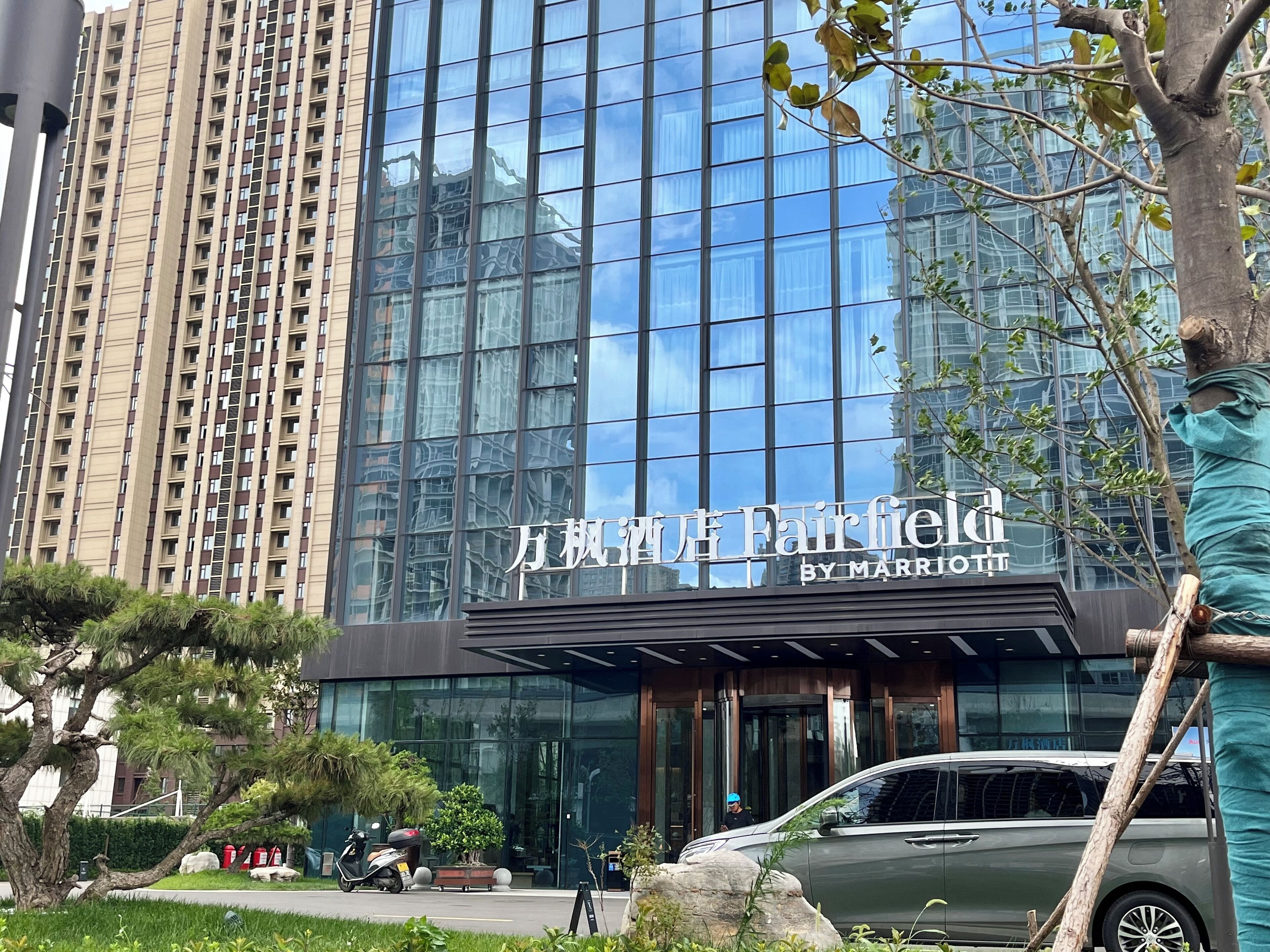 Un bâtiment moderne avec une façade en verre et une enseigne indiquant « Fairfield by Marriott ».