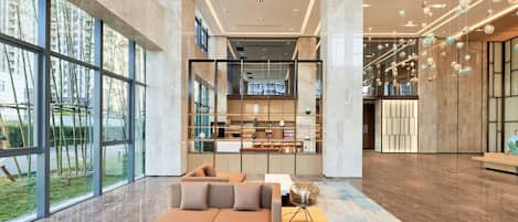 A spacious lobby with a modern sofa, a coffee table, and a patterned rug.