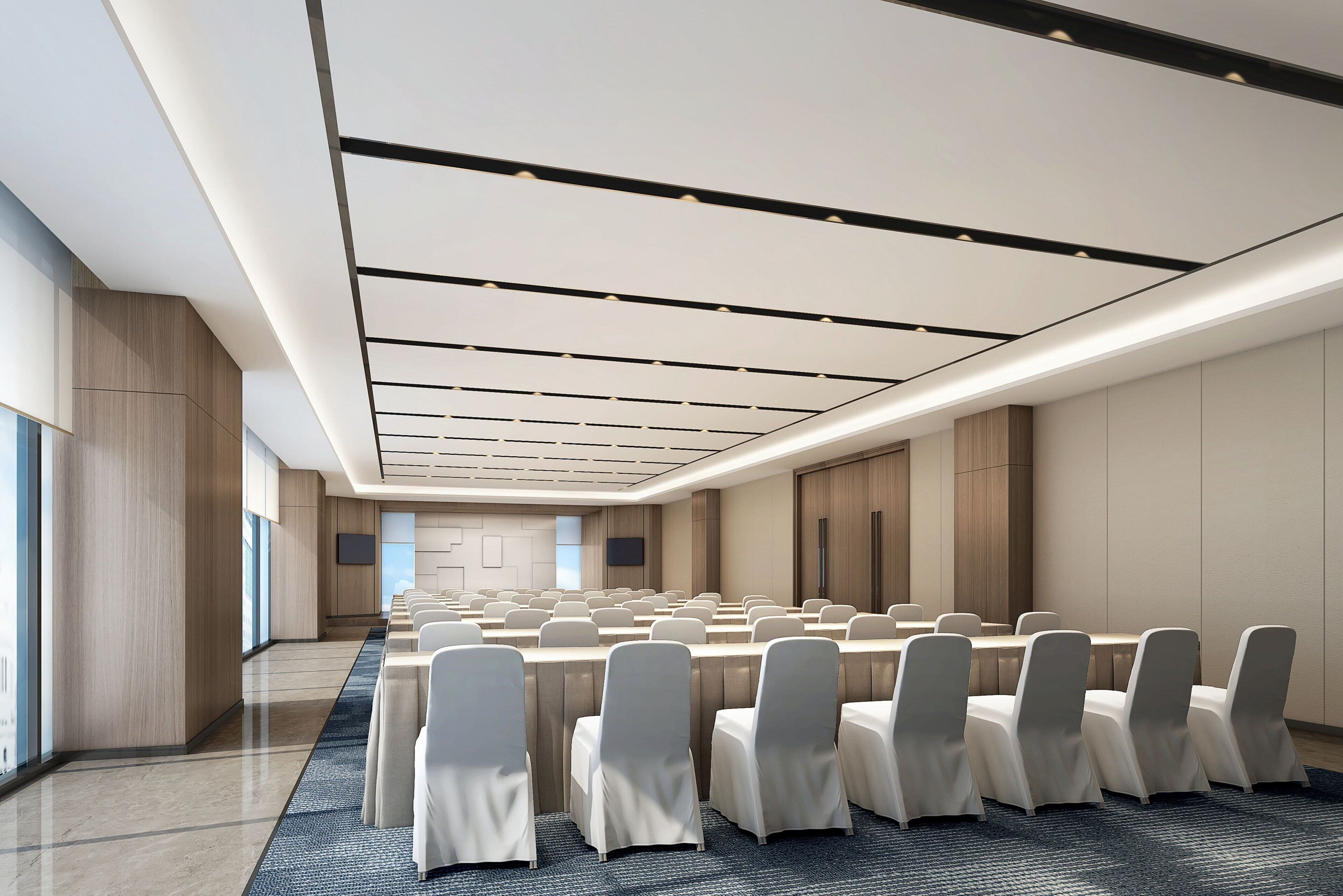 Una sala de conferencias moderna con filas de mesas y sillas, ventanas amplias y un techo plano con iluminación empotrada.