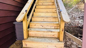 Una escalera de madera que sube hacia un edificio de aspecto sombrío.
