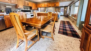 Una cocina amplia con armarios de madera, una gran mesa de comedor e isla central.