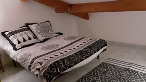Ein Schlafzimmer mit einem Bett, Kissen und einem gemusterten Teppich.