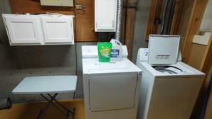 Une petite buanderie comprenant un lave-linge, un sèche-linge et une petite table.