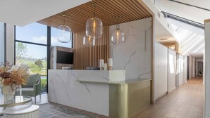 A modern kitchen with a marble countertop, pendant lights, and a view of the outdoors. - The Hazendal Hotel and Spa (Stellenbosch)