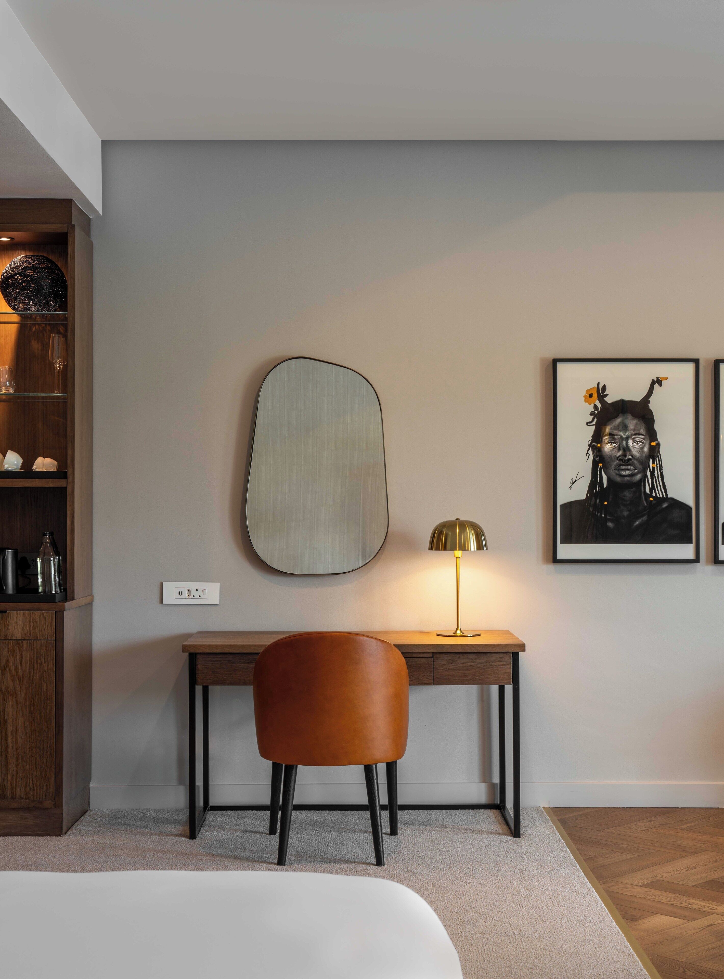 Una habitación moderna con escritorio, silla y una obra de arte en la pared.