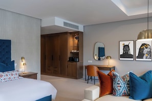 A hotel room with a bed, a desk, a chair, a wardrobe, and artwork on the wall. - The Hazendal Hotel and Spa (Stellenbosch)