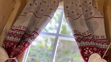 A window with wooden shutters and patterned curtains.