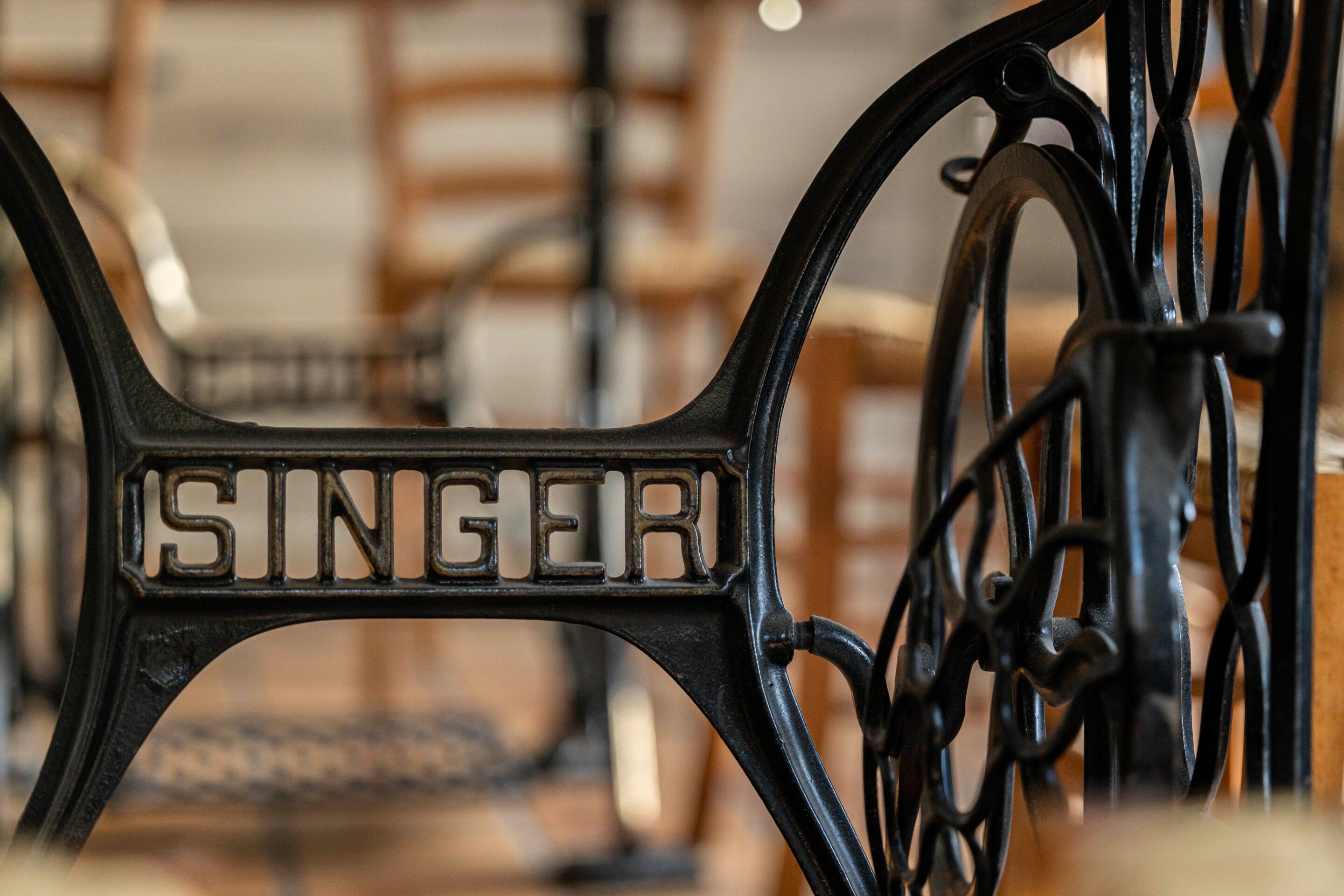 Primer plano de un soporte metálico para bicicletas con la palabra "SINGER" grabada.