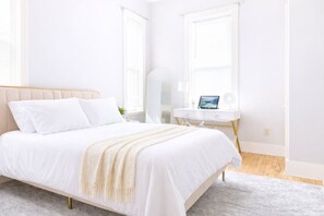 Ein Schlafzimmer mit einem Bett, einem Schreibtisch und einem Stuhl.