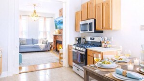 Une cuisine moderne avec des meubles en bois, un four à micro-ondes, une cuisinière et un coin repas aménagé pour prendre un repas.