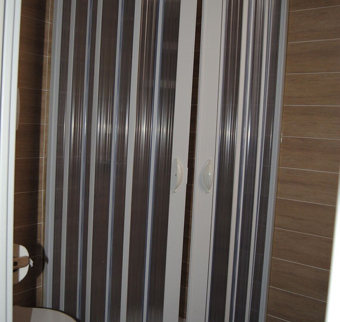 Une salle de bain avec des carreaux à rayures et un plancher en bois.