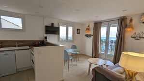 A compact apartment with a kitchenette, dining area, and a balcony with a view. - Balcon des îles d'Or - T2 seafront historic center (Le Lavandou)