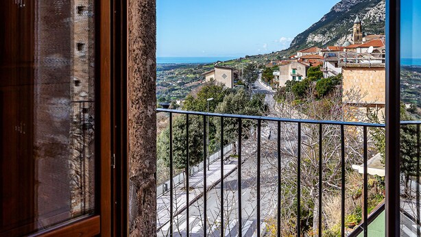 Un balcón con vistas despejadas a un pueblo y montañas.