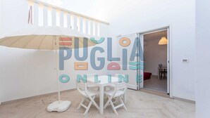 Una habitación con una mesa y sillas blancas, suelo blanco, techo blanco y pared blanca.
