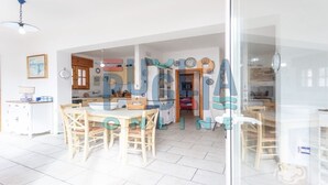 A spacious kitchen with a central island, wooden cabinets, and a dining area with a table and chairs. - Villa Pisa 2 in Torre Vado (Torre vado)