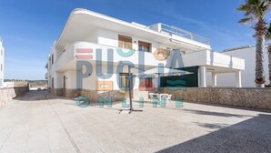 Un bâtiment moderne à deux étages, doté d’un balcon, d’une façade en pierre et surplombant un ciel dégagé.