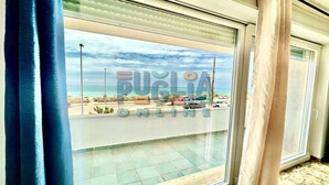 Uma varanda com vista para a praia e o mar.