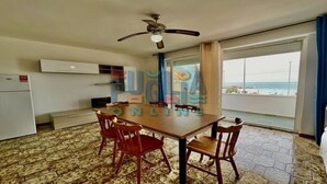 Cozinha compacta com área de jantar, ventoinha no teto e vista para o oceano.