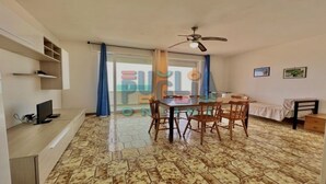 Um apartamento pequeno e moderno, com área de refeições, cama e televisão.