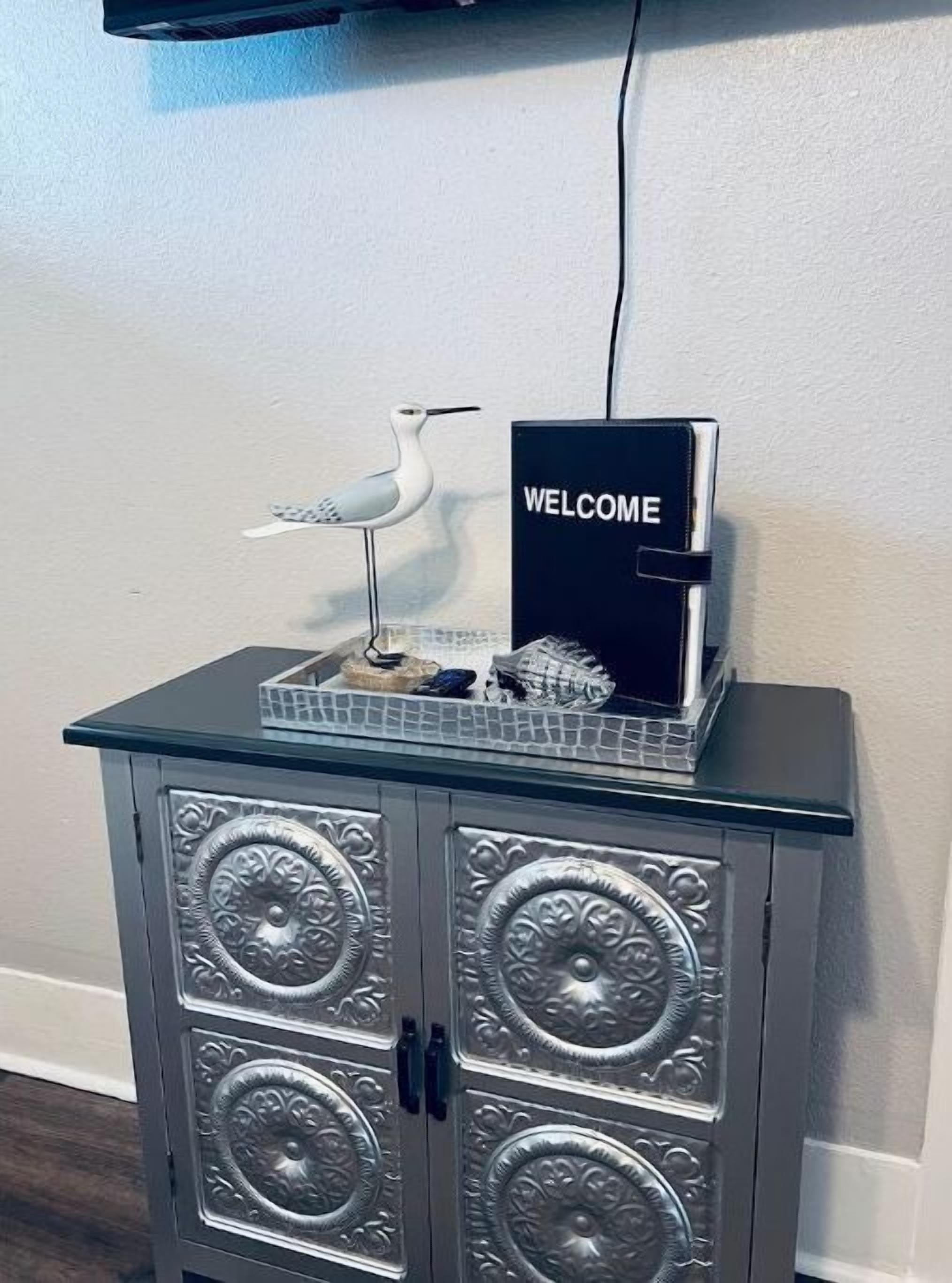 Un mueble con paneles decorativos y un letrero que dice 'WELCOME' en la parte superior.